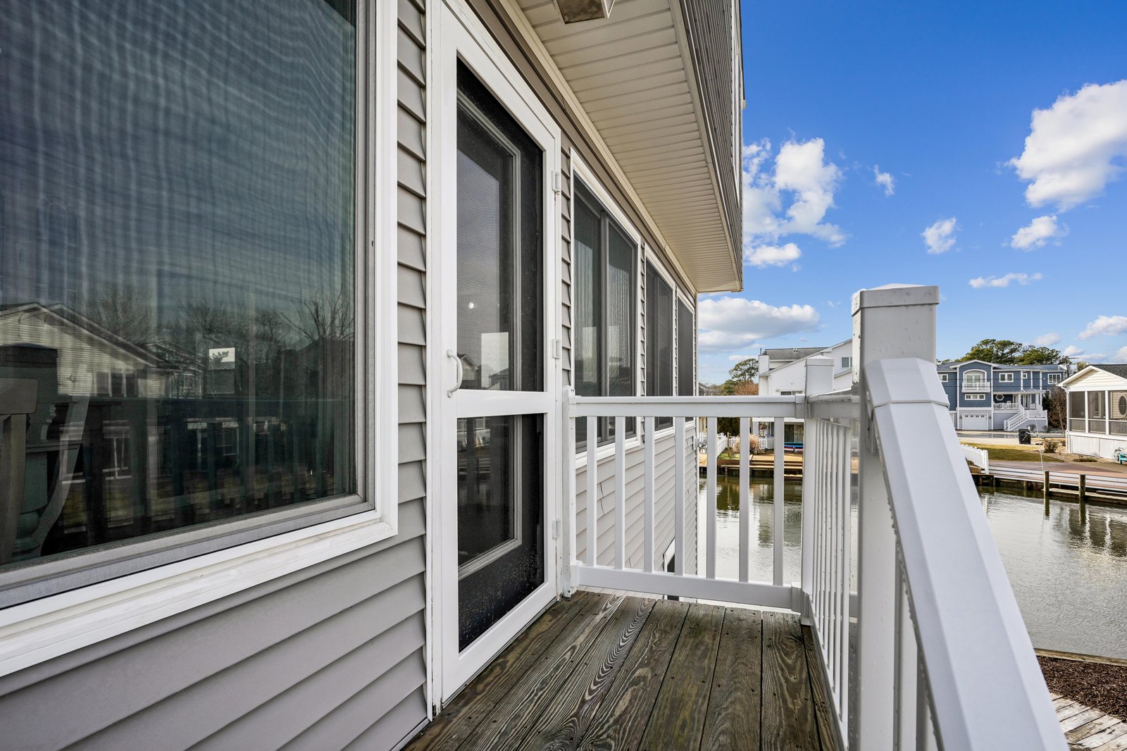 A waterfront property situated along a calm canal with nearby homes and docks, offering a peaceful neighborhood setting with easy water access.