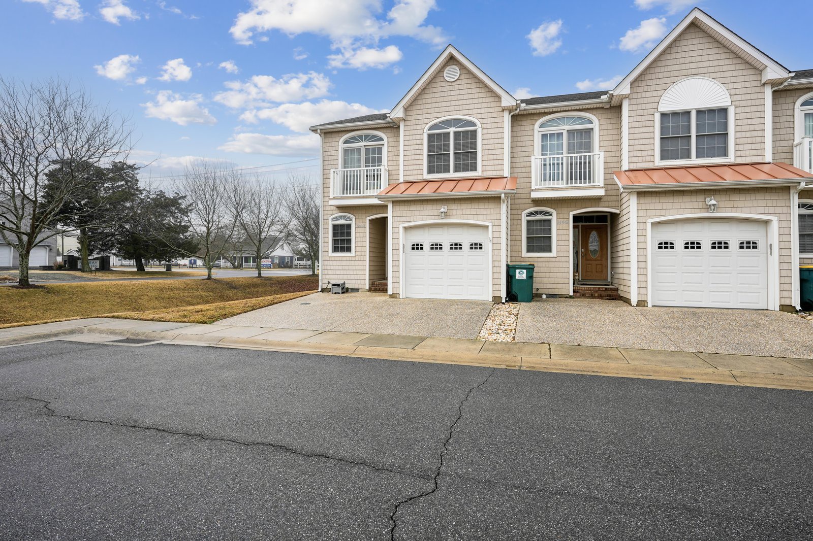The property features a multi-unit townhouse-style building with attached garages, located in a quiet residential neighborhood. Front parking and easy access enhance guest convenience upon arrival.