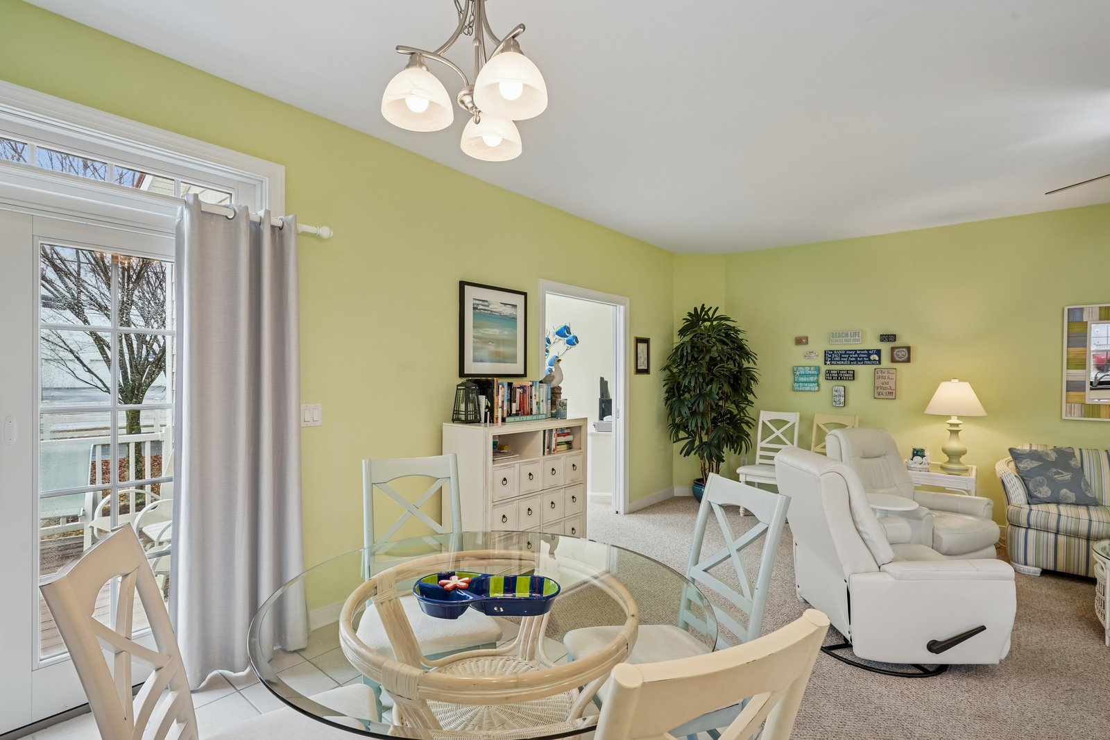 Relax in your bright, cheerful living space with soft green walls and comfortable seating perfect for unwinding after beach days.