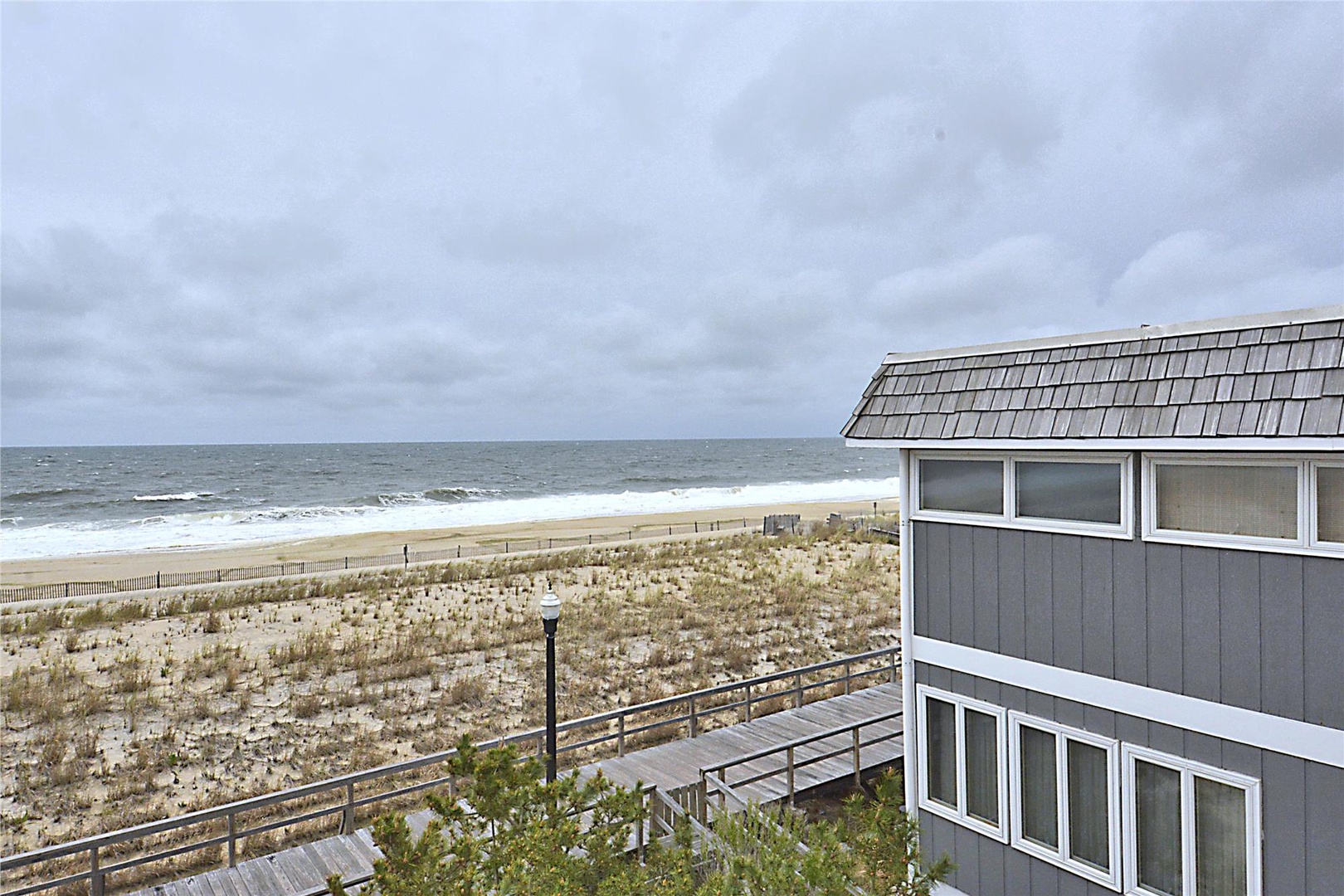 This beachfront property offers direct access to sandy shores and stunning ocean views, with a natural dune landscape providing privacy and coastal charm.