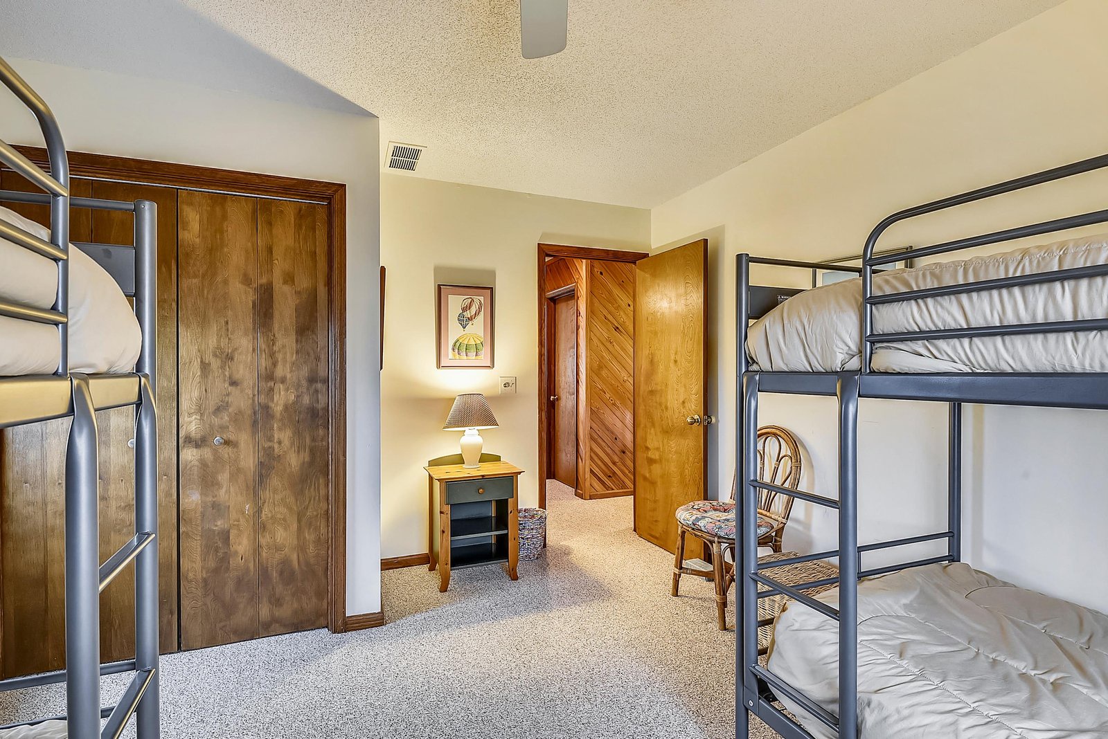 Two cozy bunk beds frame your getaway bedroom, complete with warm wood accents and a charming nightstand. Perfect for family bonding or group adventures.