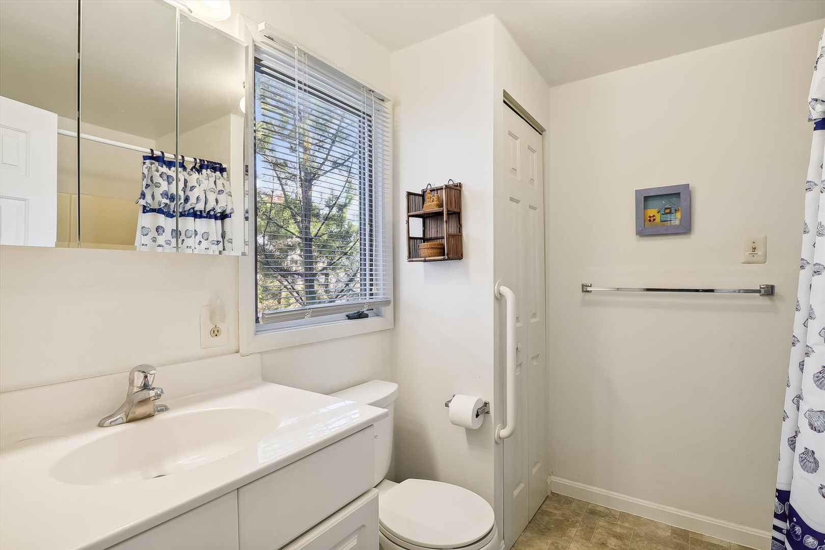 Freshen up in your bright, clean bathroom with a generous vanity, mirrored cabinet, and plenty of natural light streaming through the window.