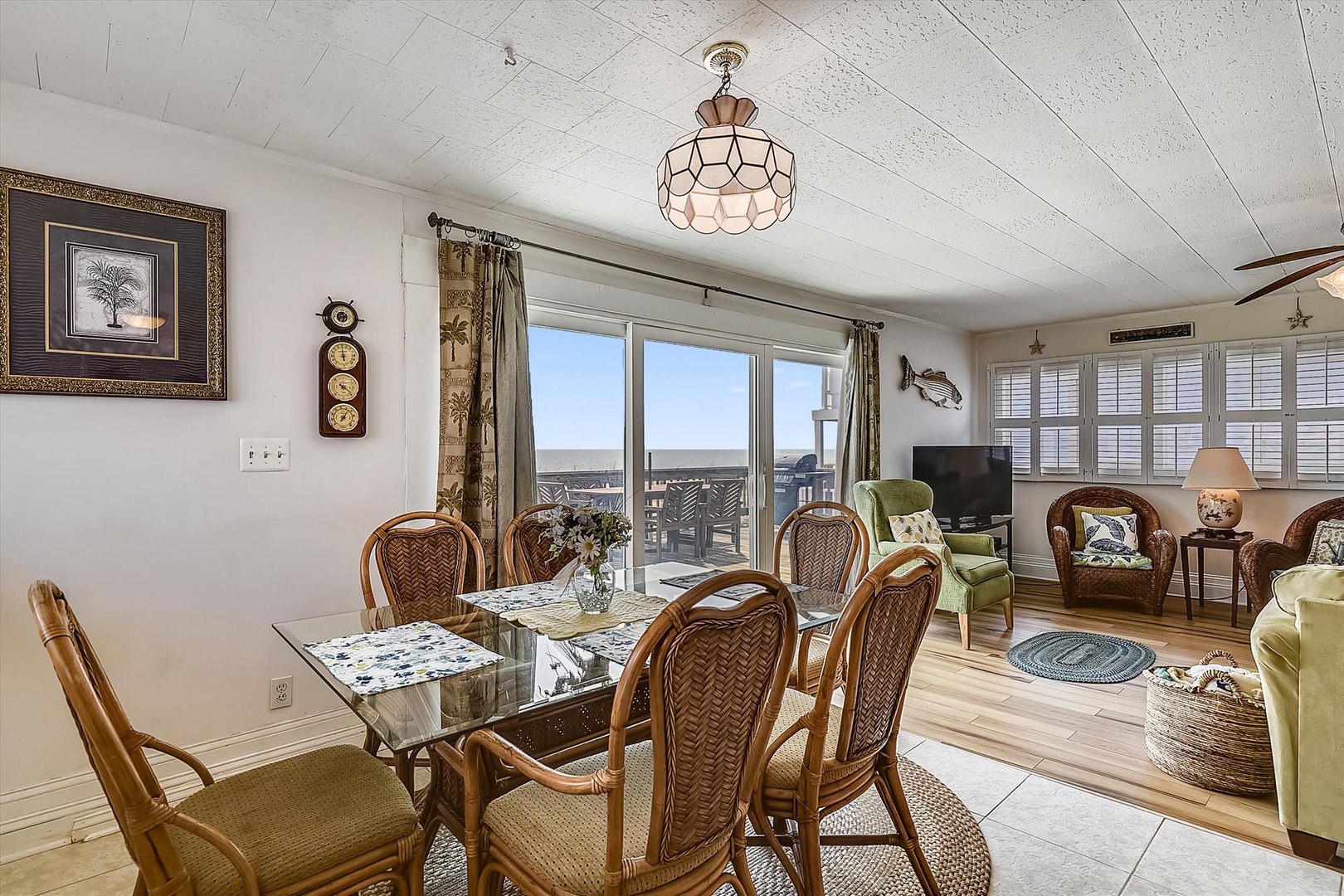 Gather around the dining table and soak in breathtaking water views through expansive windows. Coastal charm meets comfortable living, perfect for your memorable beach getaway.