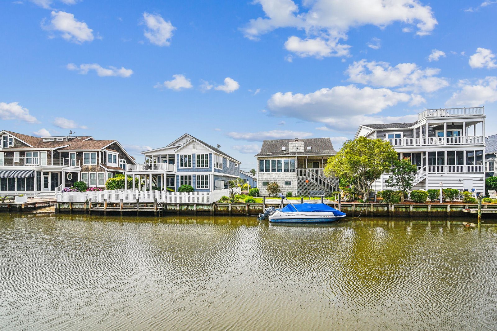 Waterfront homes line the canal with private docks and calm waters, creating a serene coastal neighborhood setting.