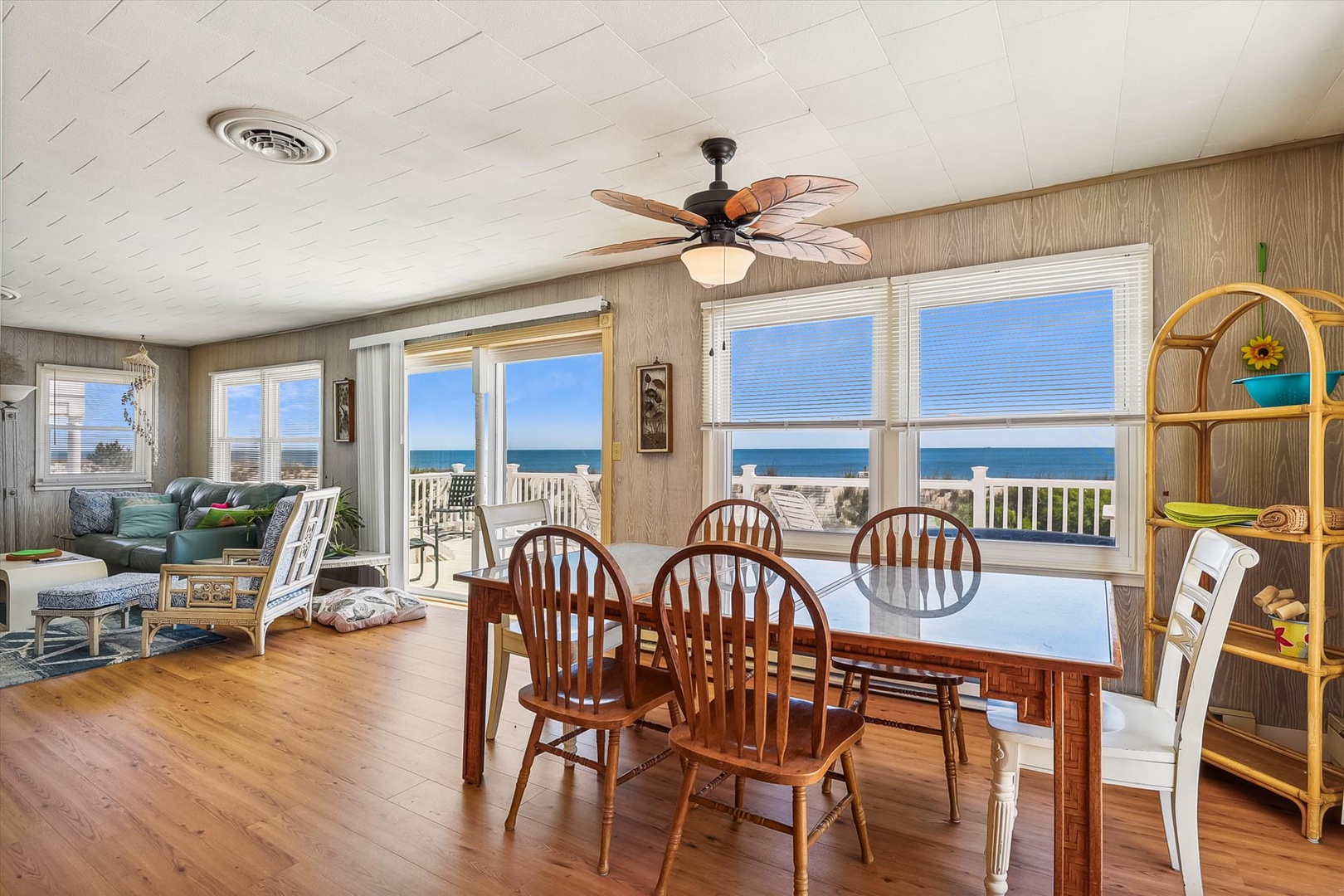 Gather for meals surrounded by stunning ocean views through every window. The spacious dining area flows seamlessly into the cozy living space, where coastal breezes and sunlight fill your beachfront retreat.