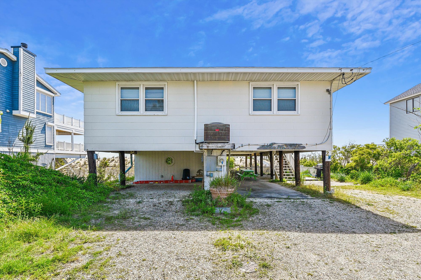 Coastal beach house with elevated design, ground-level parking, and convenient access to nearby shores.
