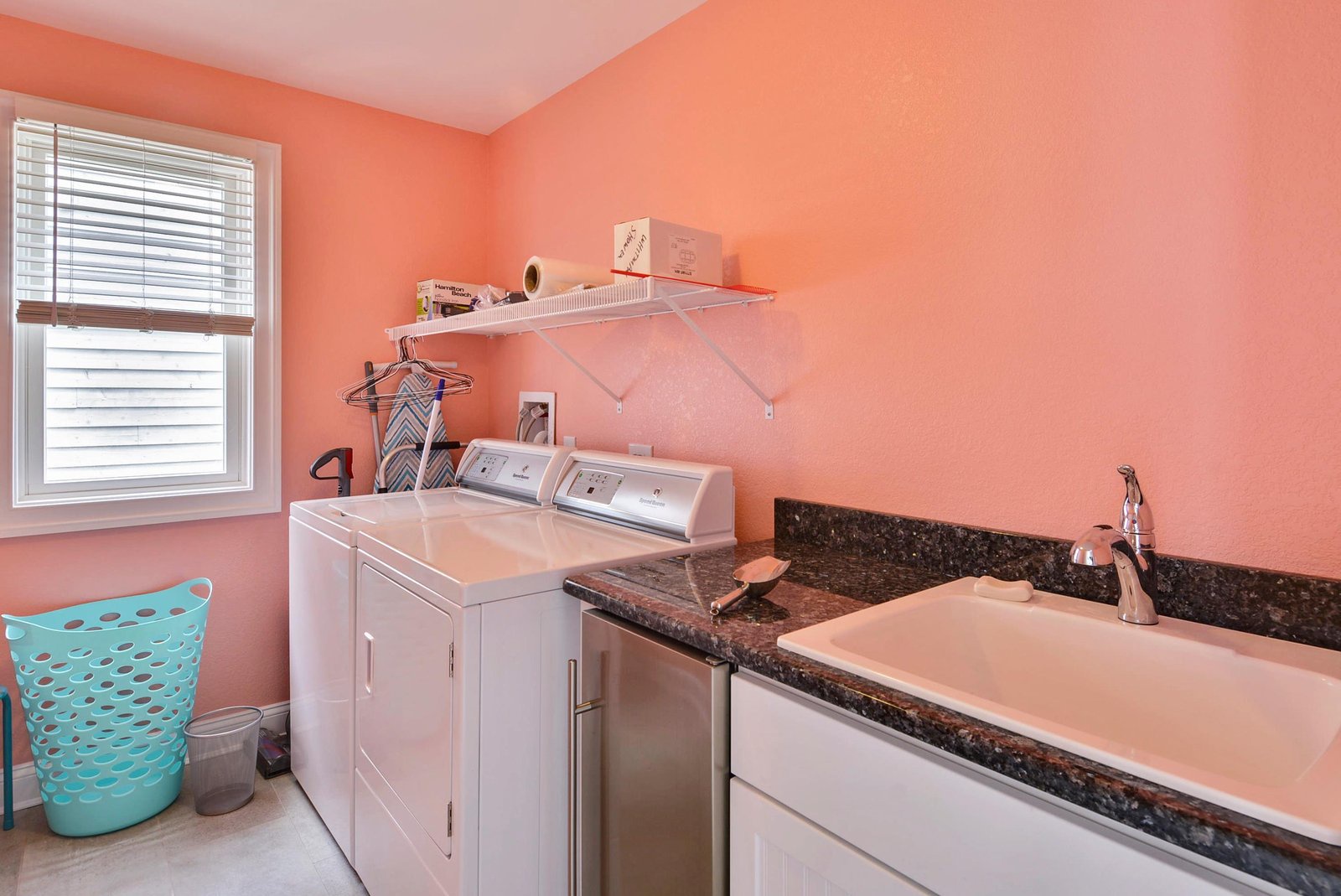 Bright laundry room with full-size washer and dryer, convenient sink, and drying rack—your vacation wardrobe stays fresh with ease.