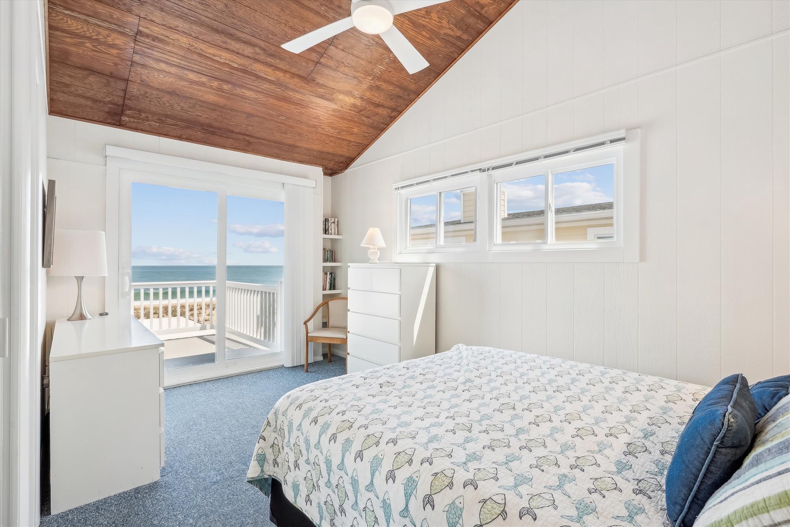Wake up to stunning ocean views from your airy bedroom, where a cozy bed awaits beneath a beautiful vaulted wood ceiling. Step through the glass doors onto your private balcony for morning coffee with endless blue horizons.