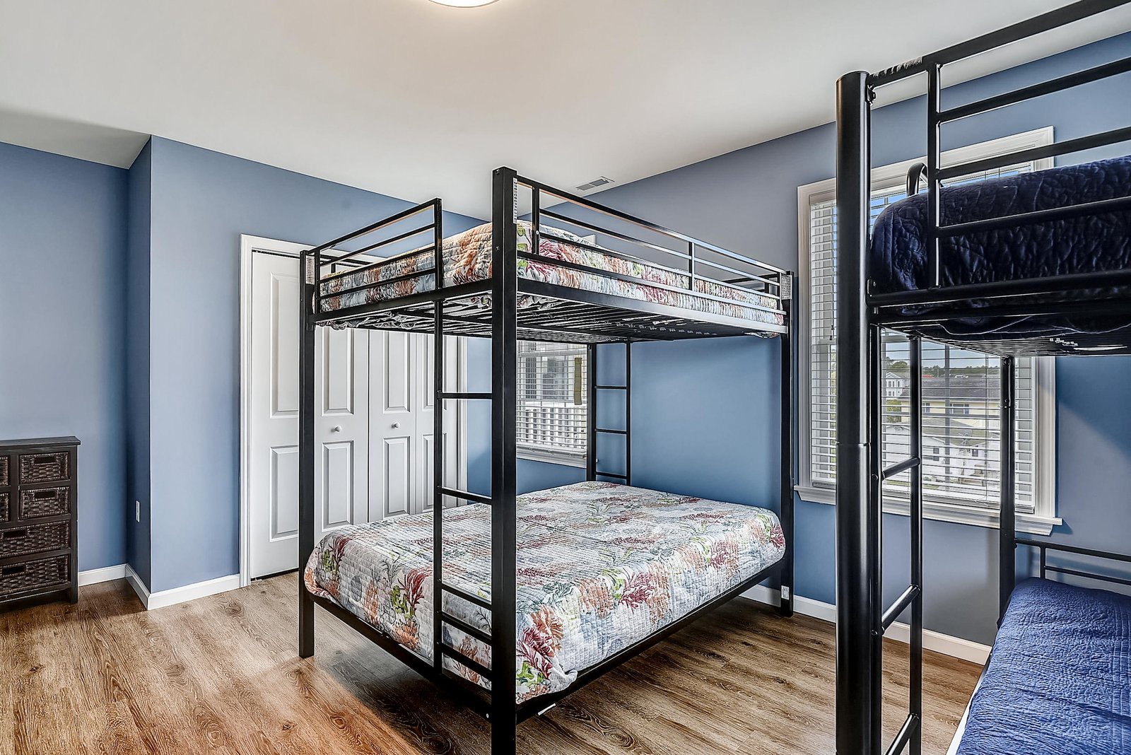 Your family will love this bright bedroom with two full-sized bunk beds and warm natural light streaming through large windows, creating a comfortable space for everyone to rest after a day of adventure.