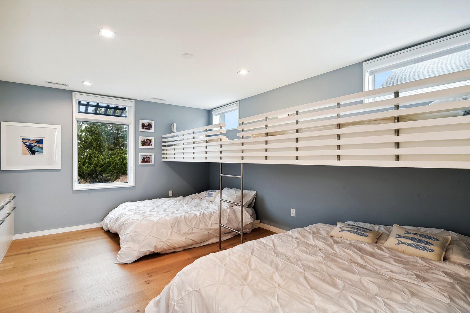 Modern bedroom with room for the whole crew, featuring a clever loft bed and crisp white linens—perfect for families or friend groups.