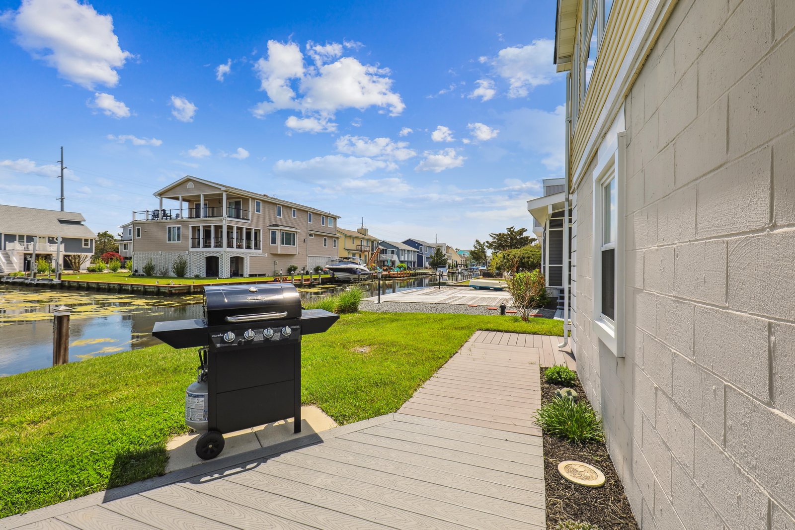 This waterfront property sits on a peaceful canal with direct water access and a dedicated boat dock. Your private BBQ grill and spacious yard invite relaxed outdoor evenings, while neighboring homes dot the serene, scenic shoreline.