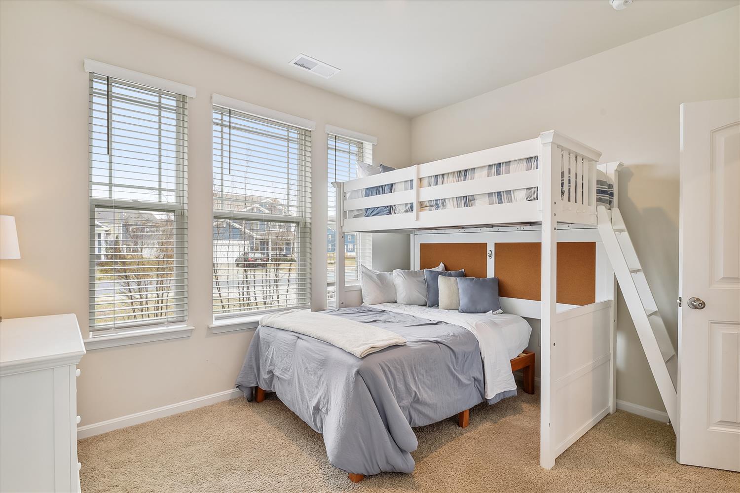 Your peaceful retreat features a cozy bunk bed setup with plush linens and warm natural light streaming through the windows, perfect for a restful night's sleep.