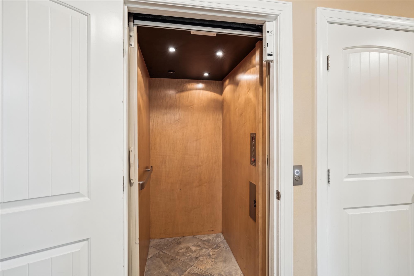 Step into the convenient elevator that ensures easy access to every floor of your rental. Warm wood paneling and thoughtful lighting create a welcoming transition between levels.