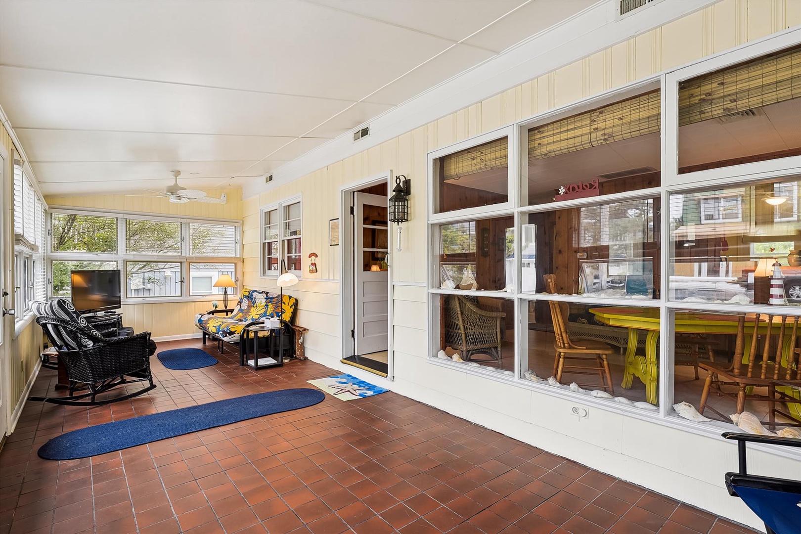 Sip your morning coffee in this charming sunlit porch, where cozy wicker seating and cheerful décor invite you to relax and watch the day unfold.