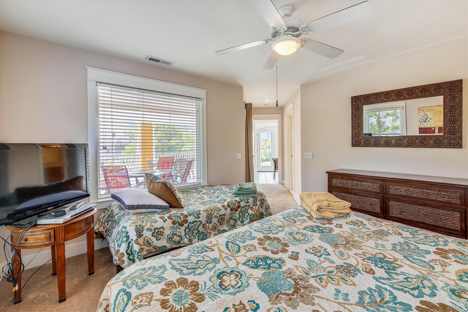 Unwind in your bright, cheerful bedroom with twin beds, a ceiling fan, and TV. Picture yourself enjoying morning views through the large window or relaxing after a day of adventure.