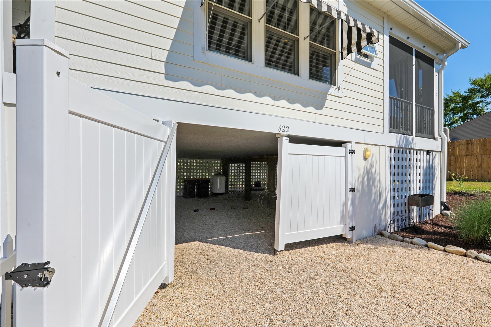 This charming coastal property features a screened porch and convenient ground-level parking beneath the main living area, located at 622 in a sunny, tree-lined neighborhood.