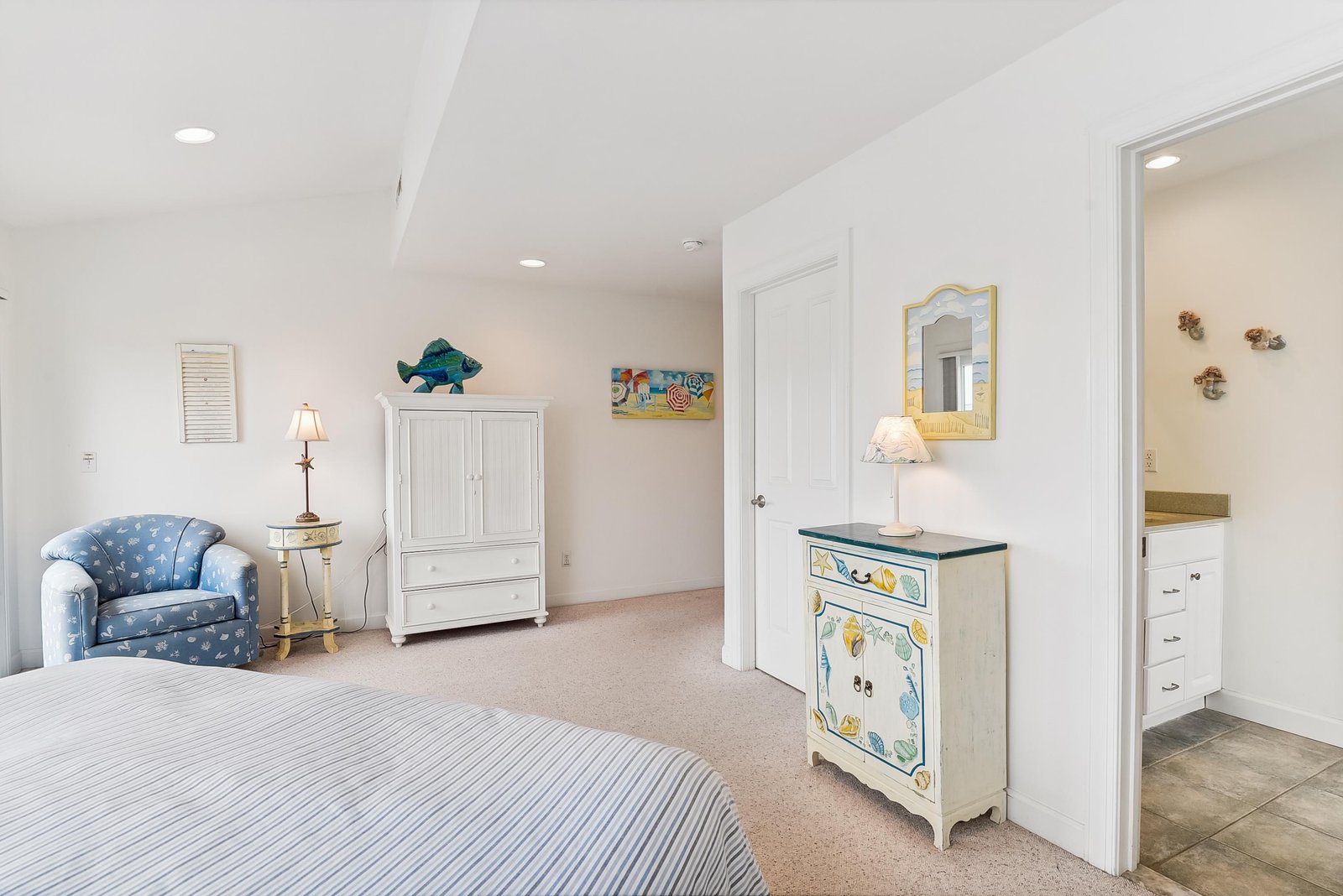 Your spacious bedroom feels bright and airy with coastal charm, featuring a cozy sitting area and an ensuite for your convenience.