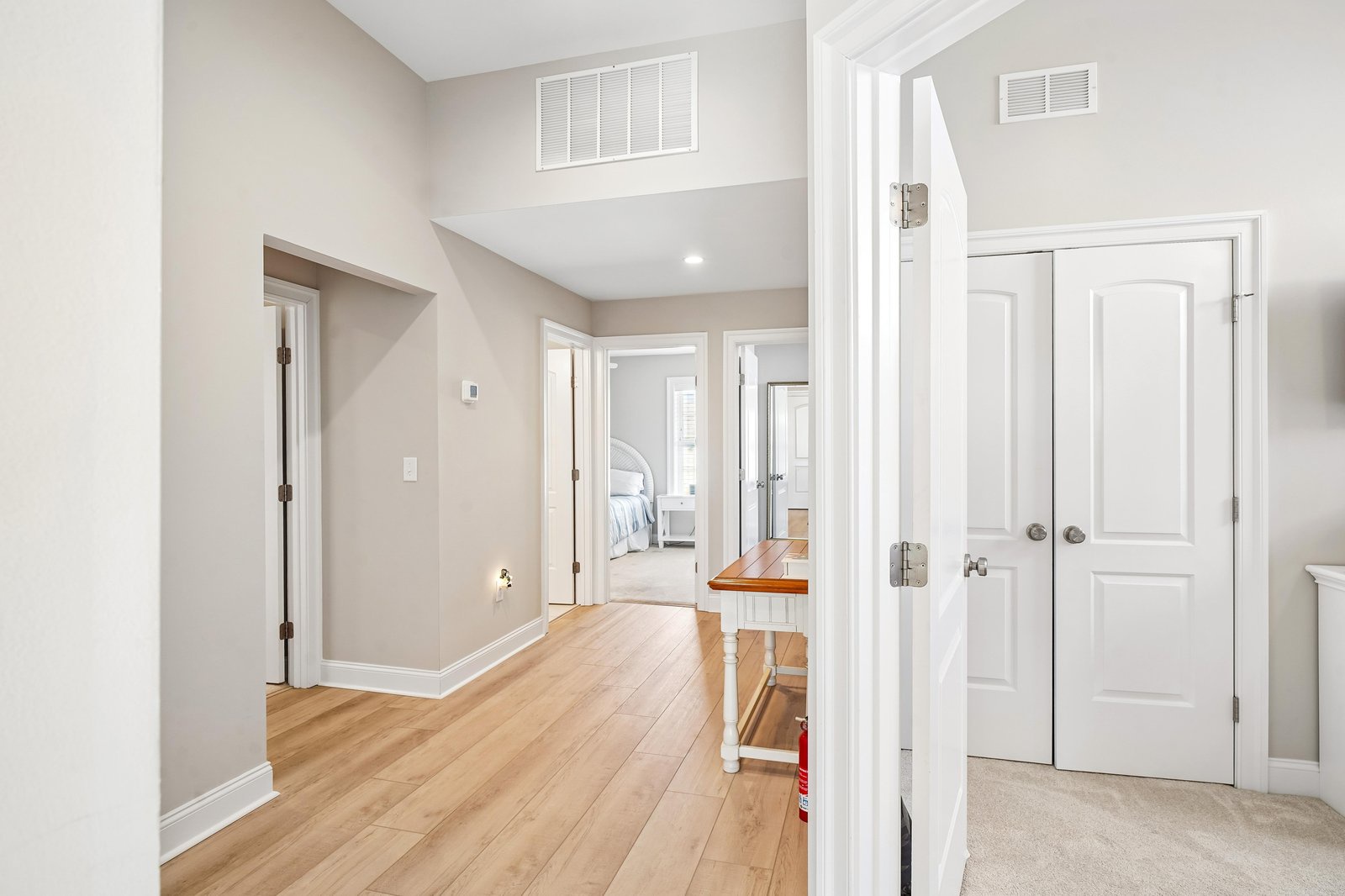 A bright hallway leads you to your peaceful bedroom retreat, with warm wood floors and airy ceilings creating a welcoming first impression the moment you arrive.