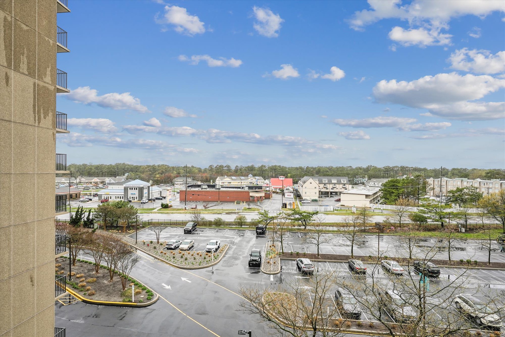 Urban landscape view showcasing the surrounding commercial district and parking areas from an elevated building perspective.