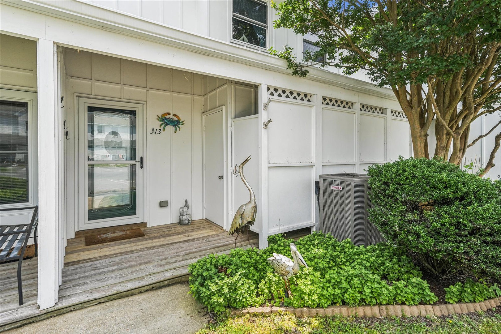 A welcoming coastal-style entrance with beach-themed decor and lush greenery greets you at the property's front door, creating a charming first impression.