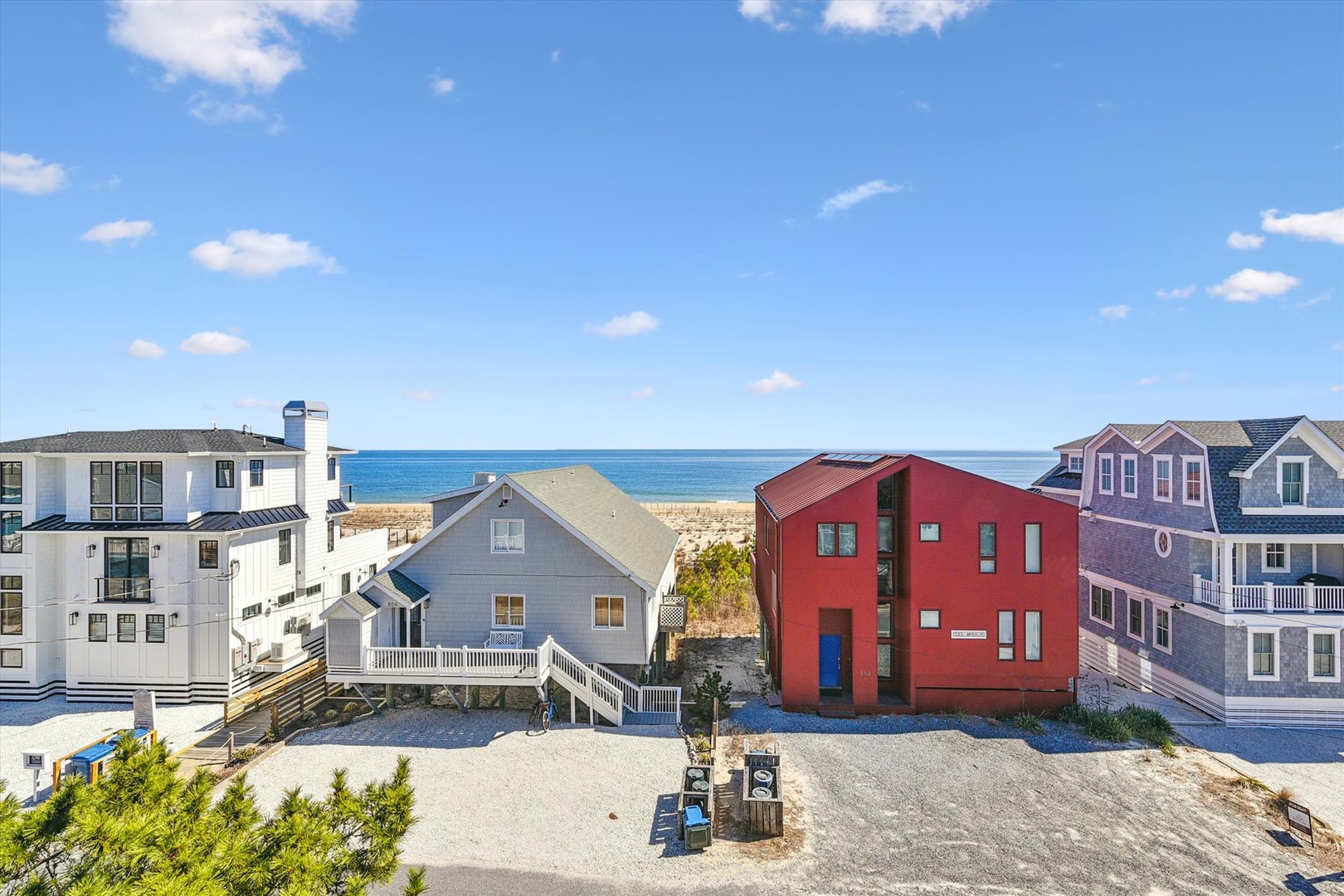 Colorful beachfront homes create a charming coastal community with direct ocean access and sandy shores just steps away.