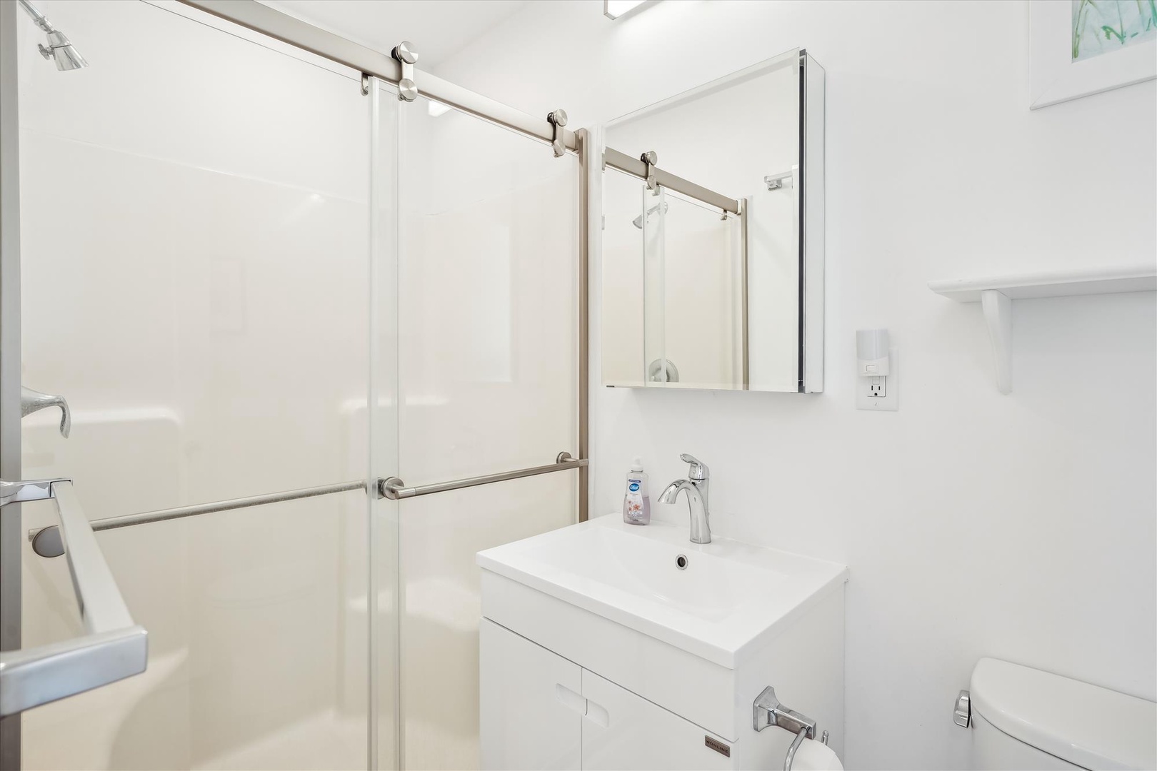 Step into this bright, modern bathroom featuring a sleek glass-enclosed shower, contemporary vanity, and fresh white finishes throughout. Everything you need to refresh after a day of adventure.