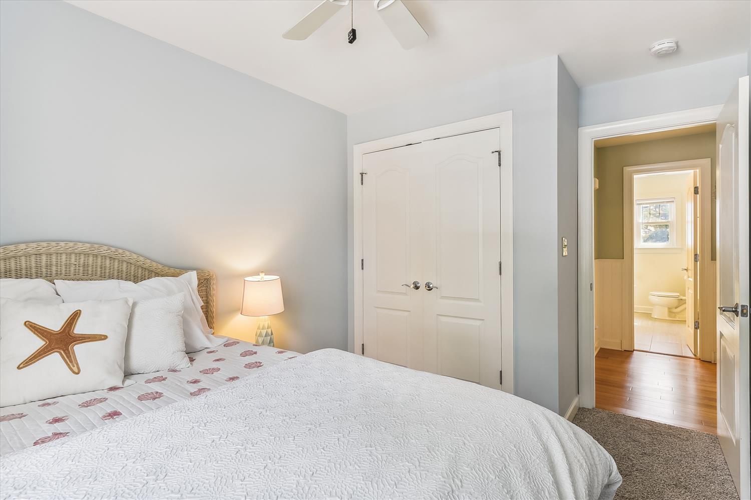 Rest easy in your serene coastal bedroom, where a comfy bed and gentle ocean-inspired decor create the perfect escape. A ceiling fan keeps you cool while you dream of seaside adventures.