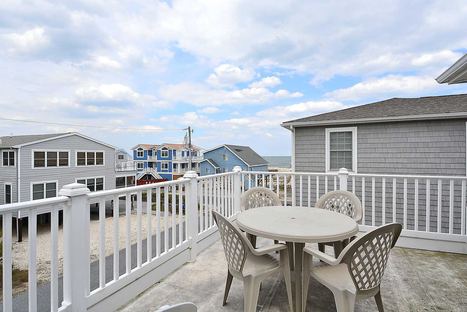 This elevated deck overlooks a quiet coastal neighborhood, with water views peeking between homes. Your perfect spot for morning coffee or sunset cocktails.
