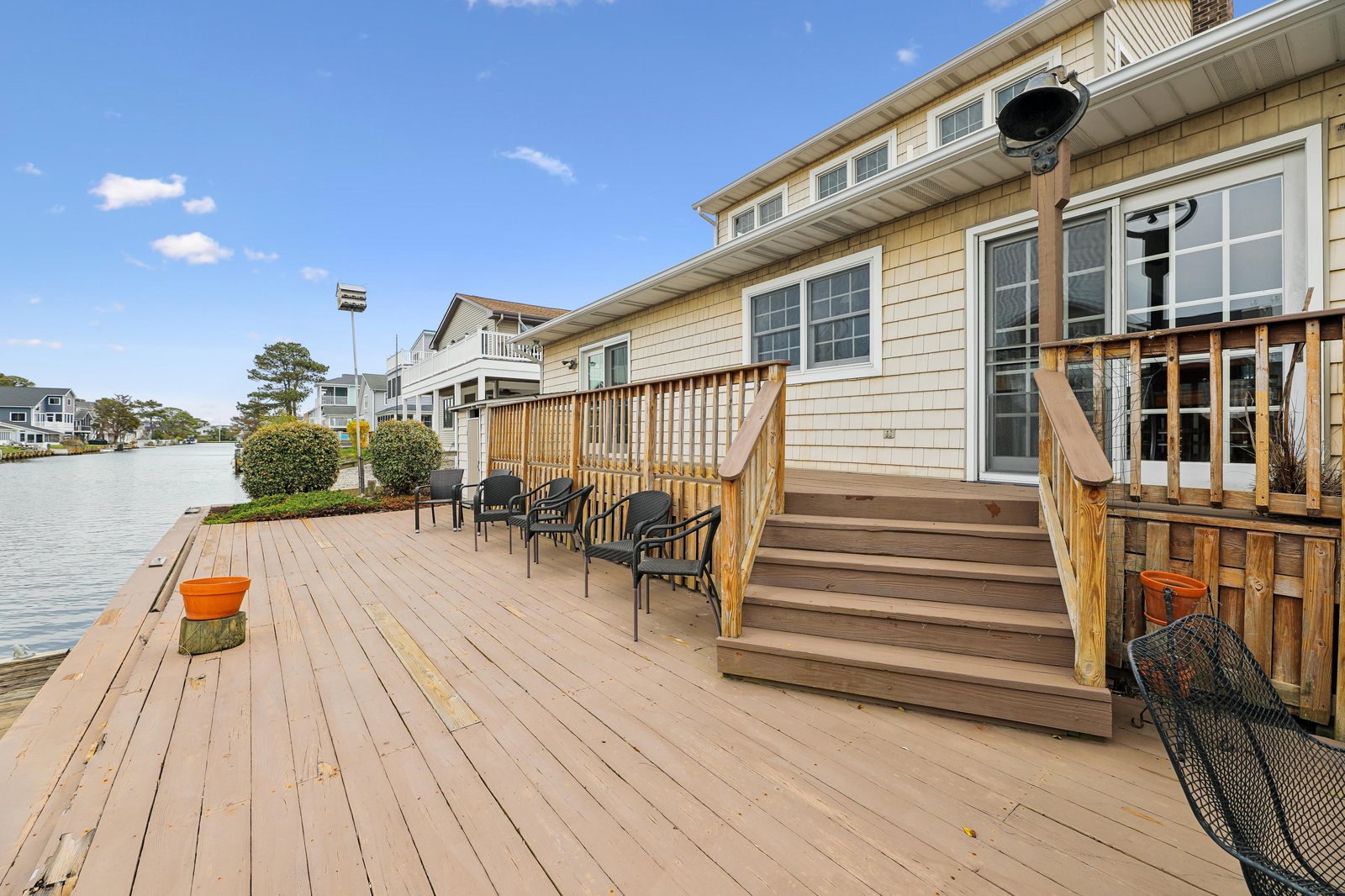 Expansive waterfront deck with generous seating and direct access to your private dock—perfect for morning coffee by the water or evening gatherings under open skies.