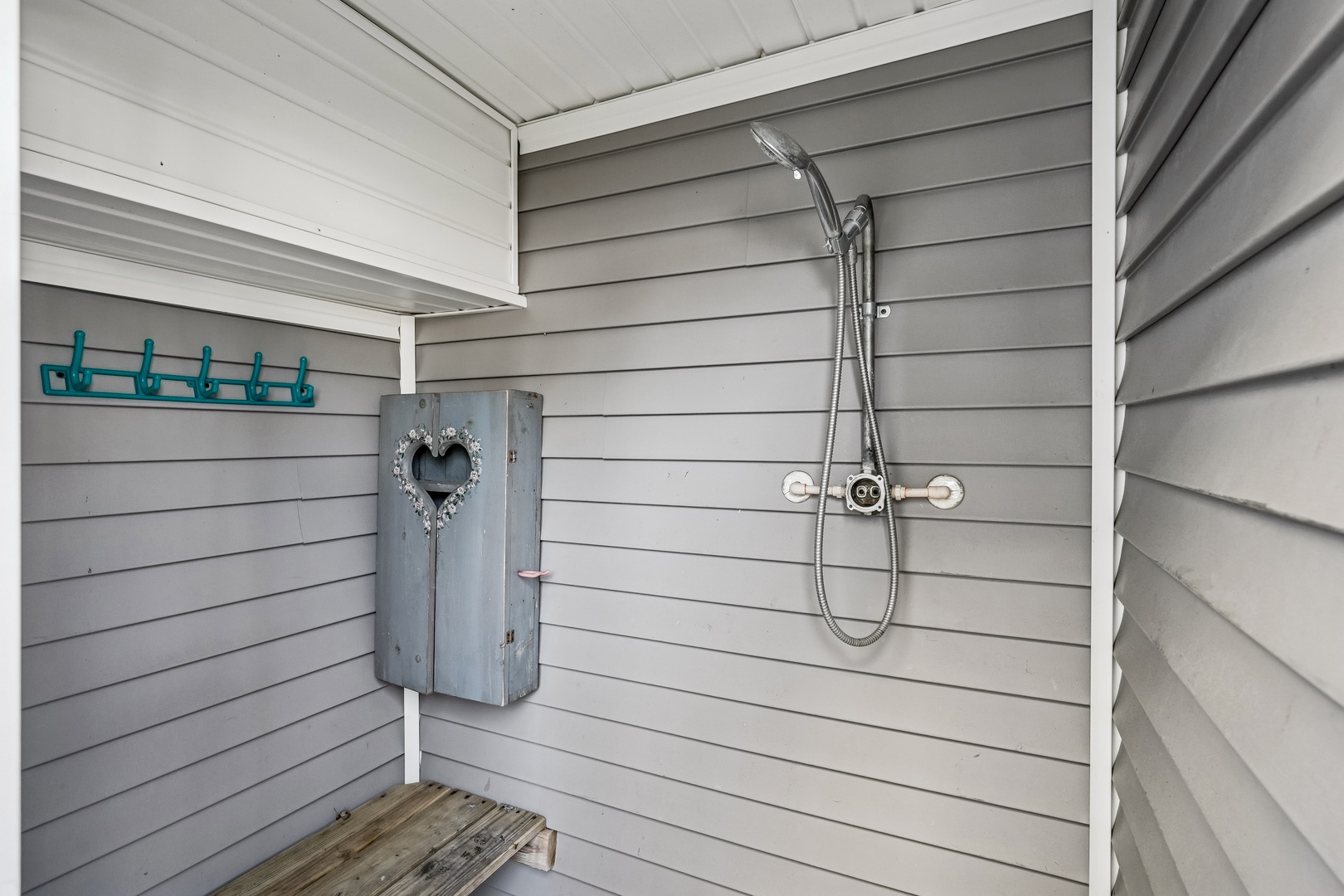 Rinse off after your beach day in your private outdoor shower with charming hooks and rustic touches.