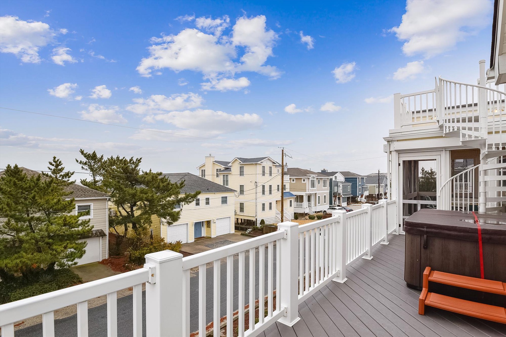 Expansive deck with hot tub and sweeping neighborhood views creates the perfect spot for morning coffee or evening relaxation under open skies.