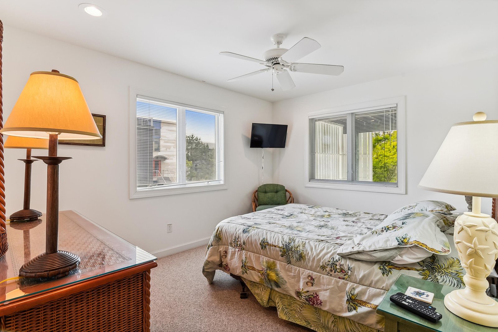 Drift off in your bright, airy bedroom where a ceiling fan keeps you cool and windows welcome natural light. The tropical-print bedding adds a cheerful, island-inspired vibe to your peaceful retreat.