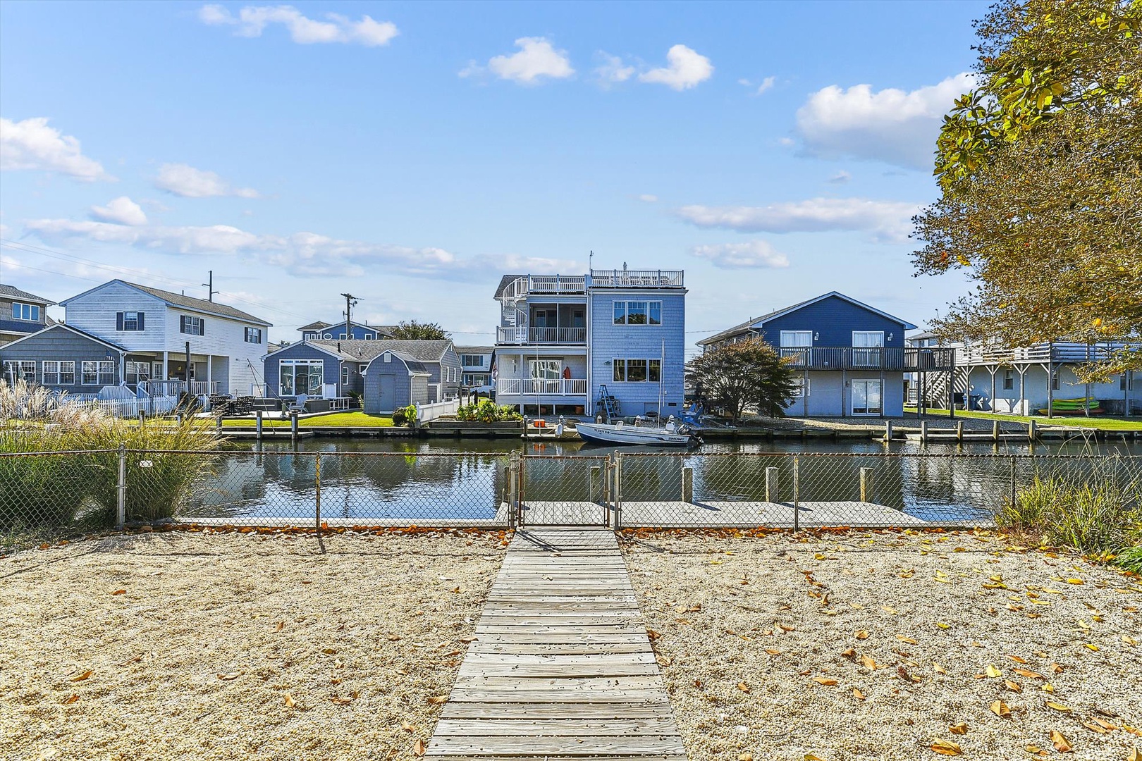 Waterfront property with private dock access in a quiet canal neighborhood, featuring residential homes with direct water views and autumn foliage.