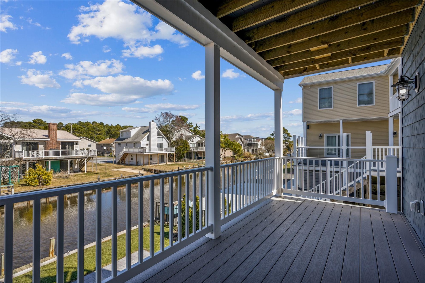 A covered waterfront balcony offering peaceful canal views and a shaded retreat, perfect for morning coffee or evening relaxation in your coastal escape.