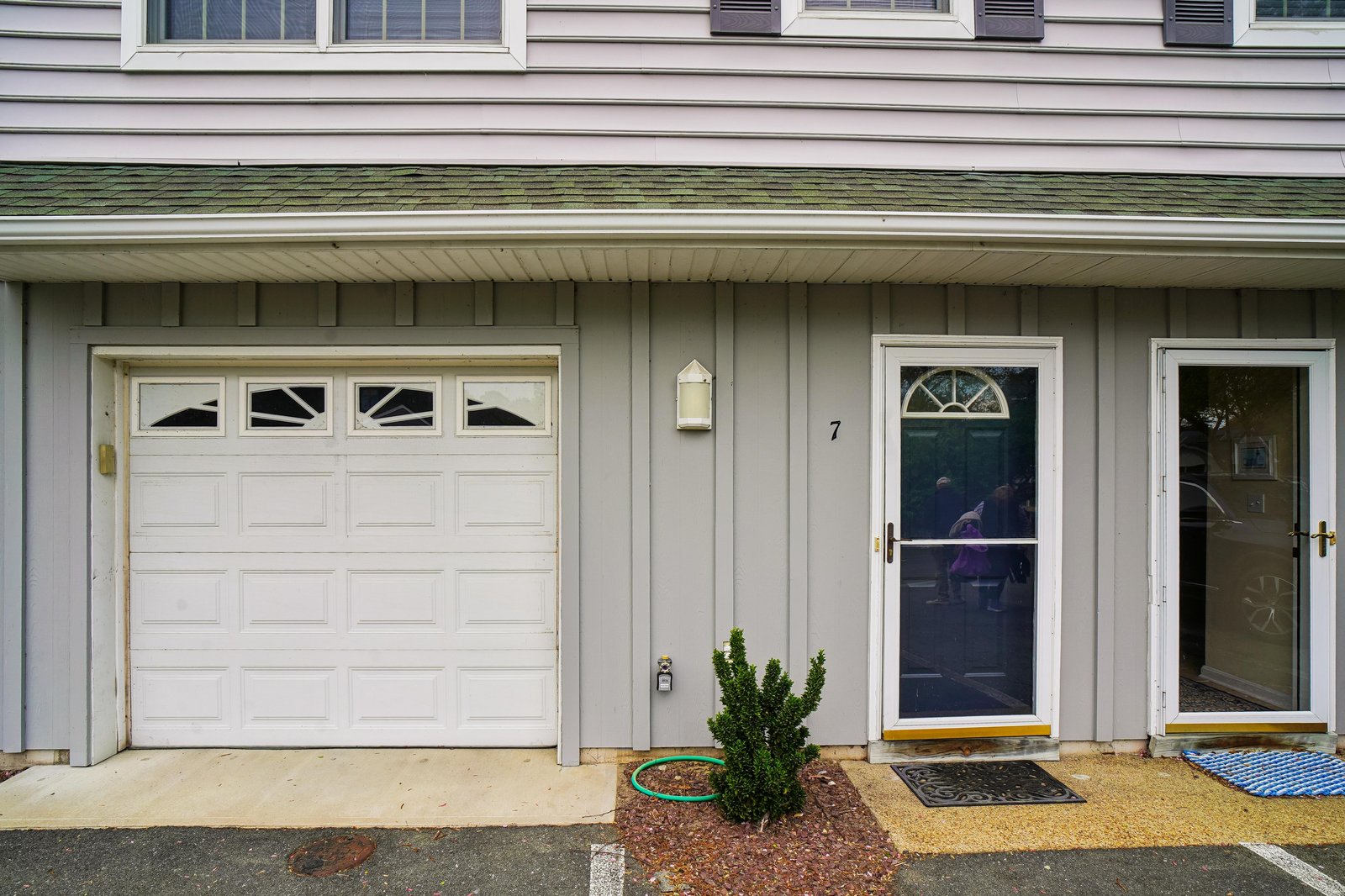 The entrance marked number 7 features a welcoming front door with decorative glass panel and convenient garage access.