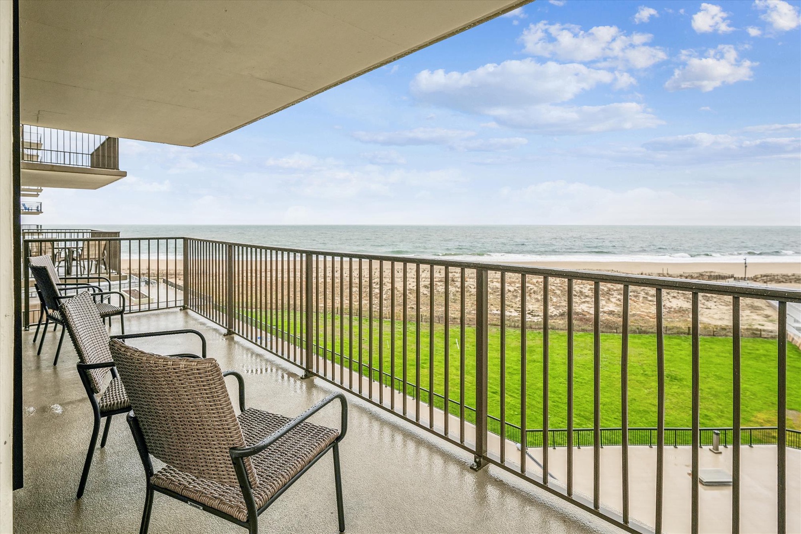 Oceanfront balcony offers stunning sea views with comfortable seating overlooking pristine beach and rolling waves.