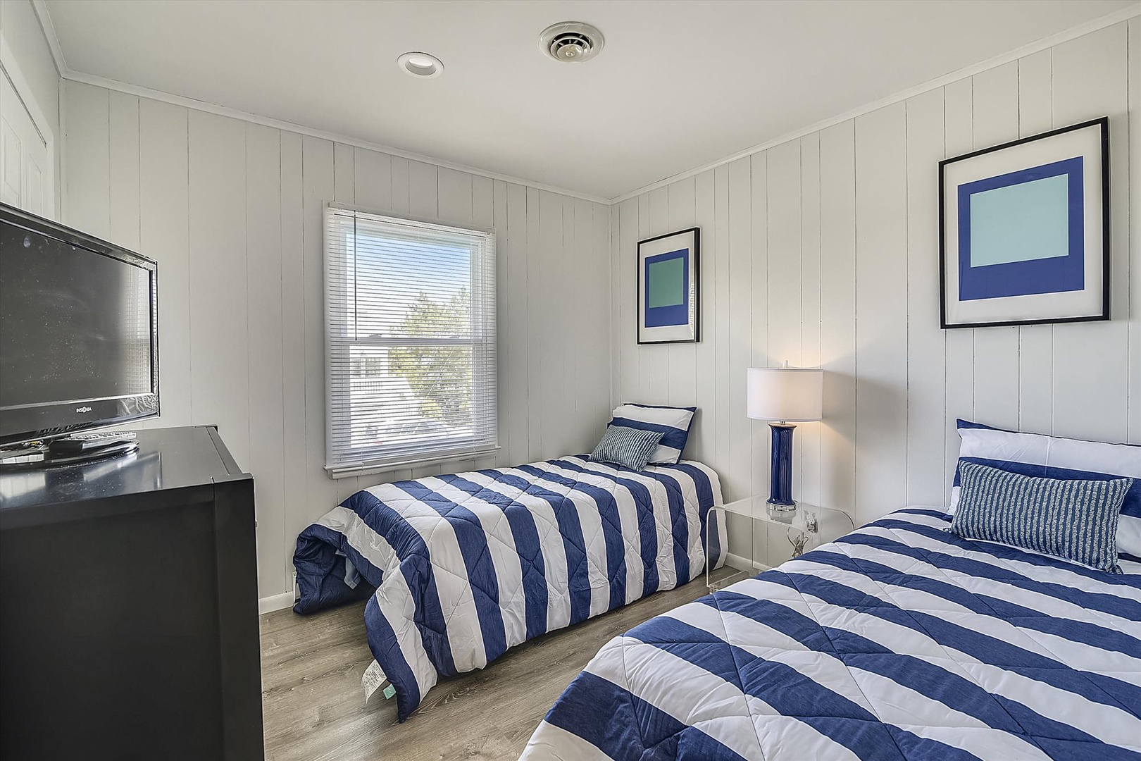 Rest easy in this bright bedroom with twin beds dressed in crisp nautical stripes, a flat-screen TV for your entertainment, and charming coastal decor that helps you unwind after your daily adventures.