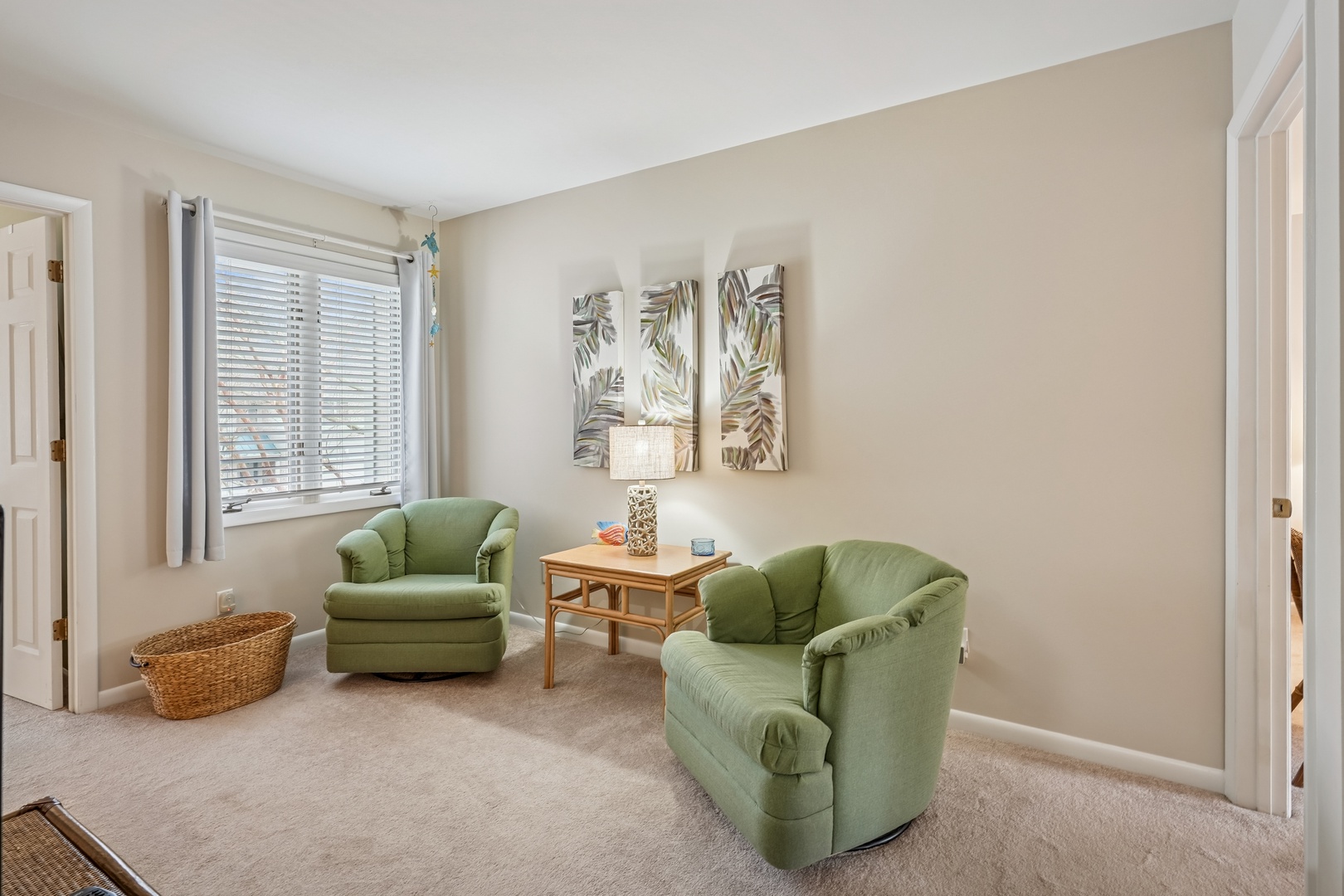 Sink into plush sage-green armchairs in your private reading nook, where tropical artwork and natural light create the perfect escape.