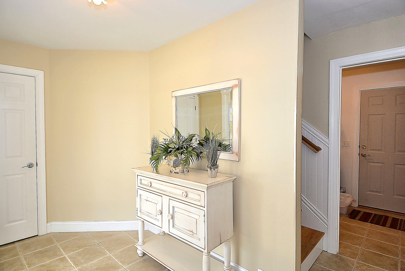 Step through your private entrance into a warm, sunlit foyer where coastal-inspired decor and soft tile floors set a welcoming tone for your stay.