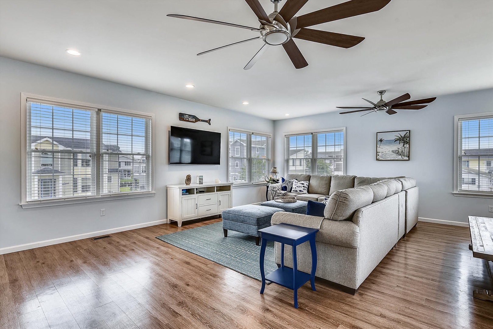 Sink into your spacious sectional and unwind in this bright, airy living room where coastal breezes flow through large windows and ceiling fans keep you perfectly comfortable year-round.