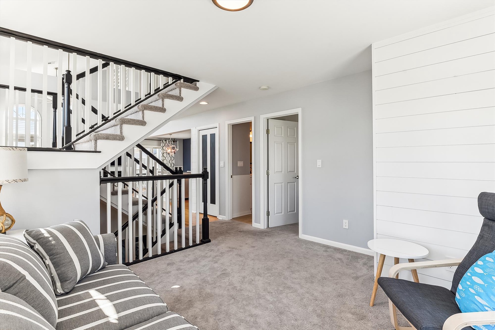 Relax in your bright, open living space with charming shiplap accents and a cozy staircase that adds character to the home.