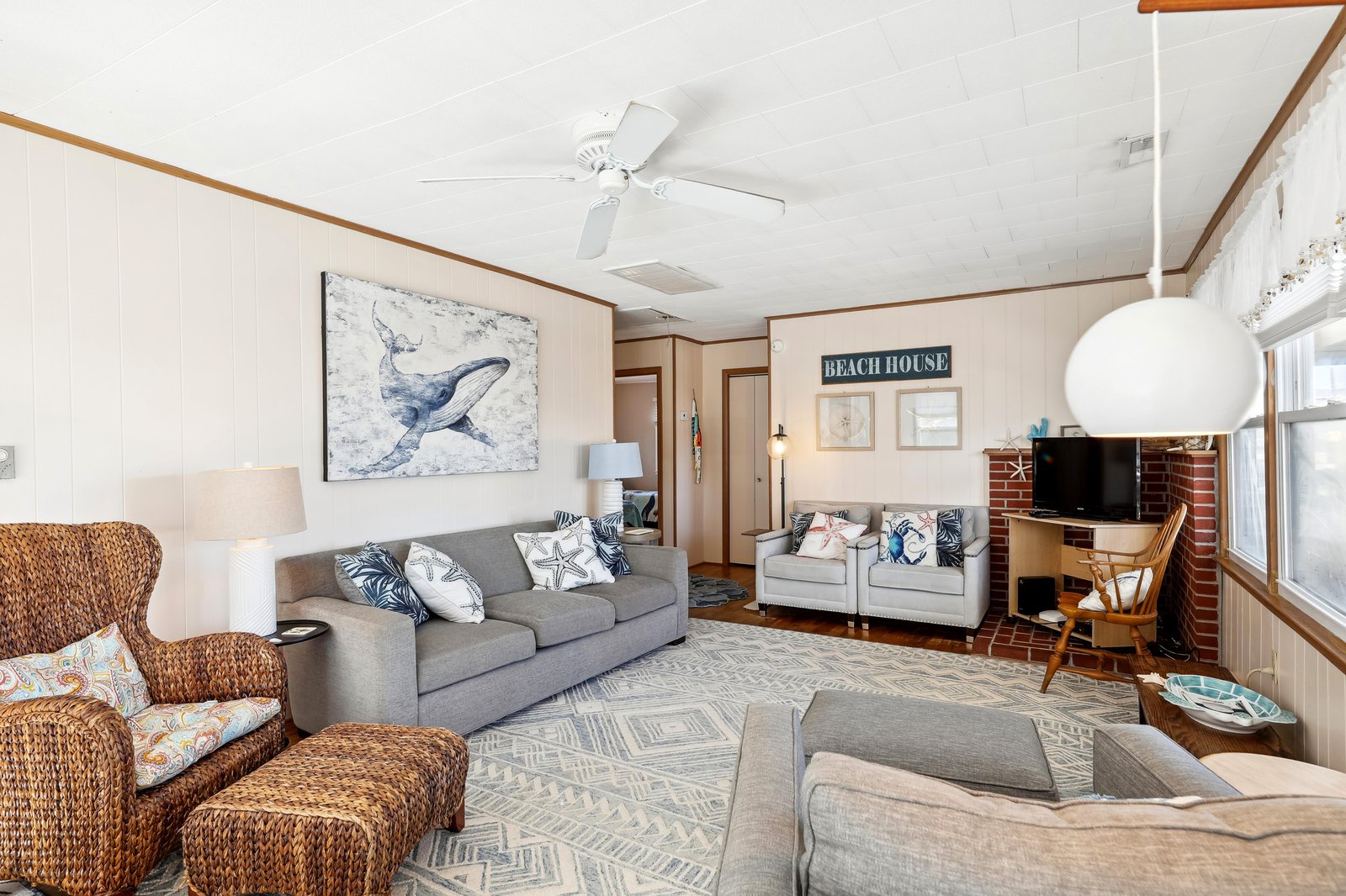 Step into your coastal retreat where nautical charm meets comfort—soft gray seating, woven textures, and breezy whites invite you to kick back and feel right at home.
