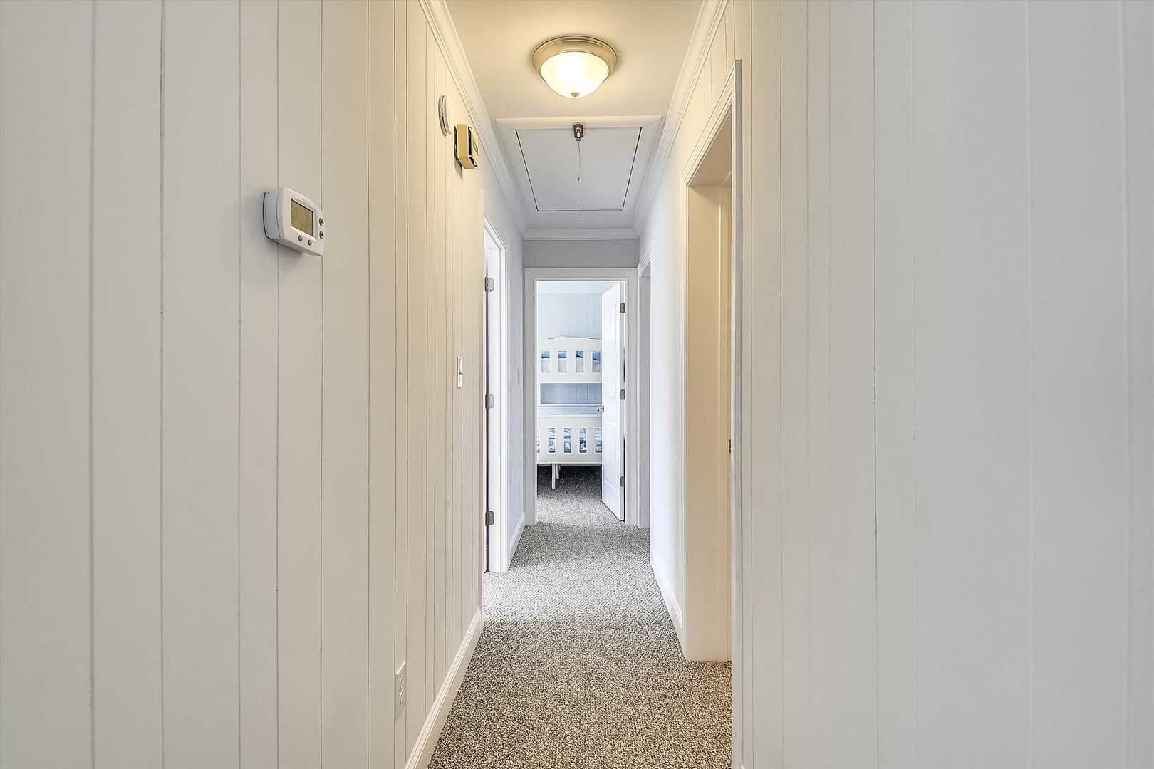 Bright hallway connects your private rooms with soft carpeting and crisp white walls that create a fresh, welcoming feel throughout your stay.