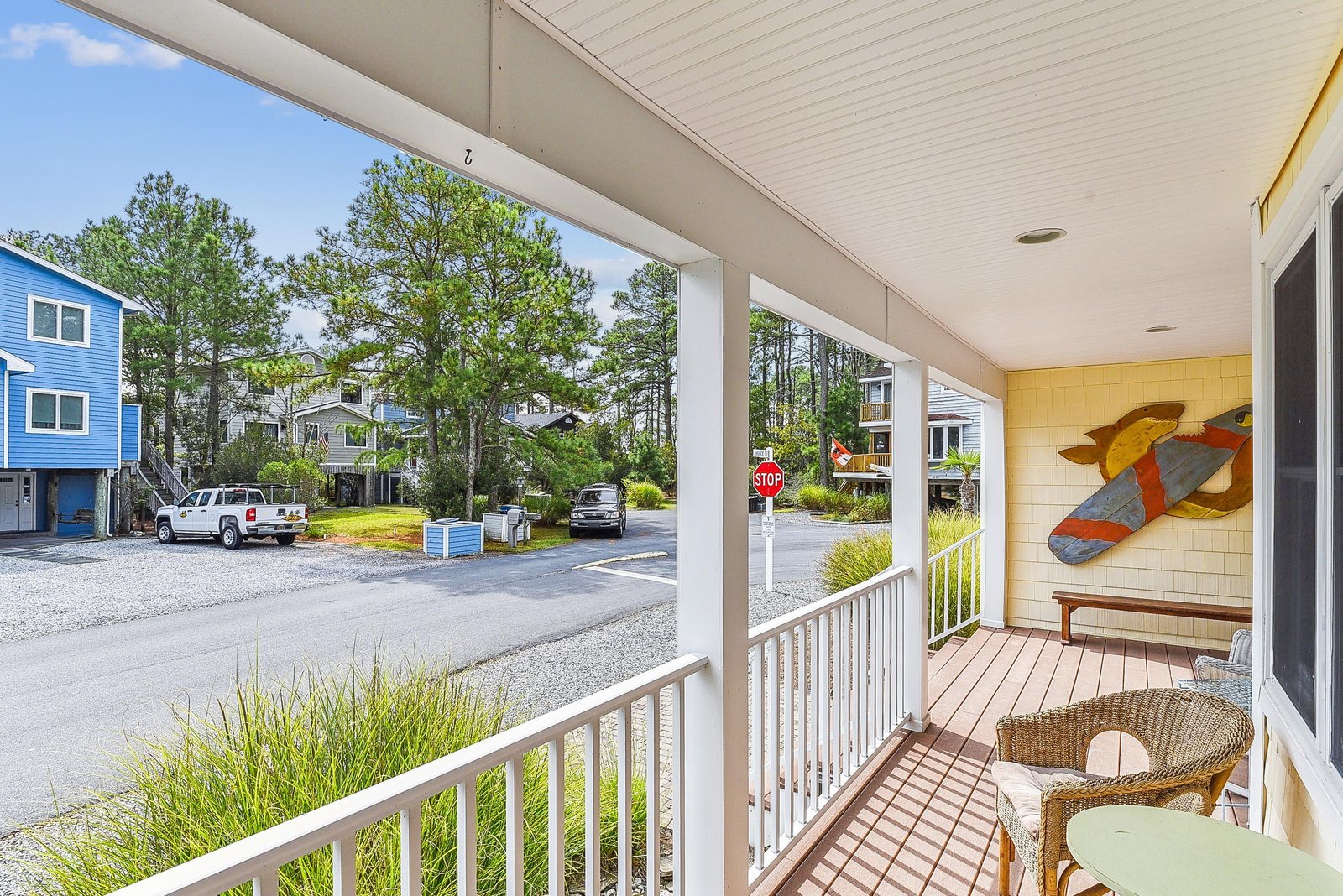 This charming covered porch offers a peaceful perch to enjoy the coastal neighborhood. Relax in comfortable seating and take in the tree-lined streets and nearby homes.