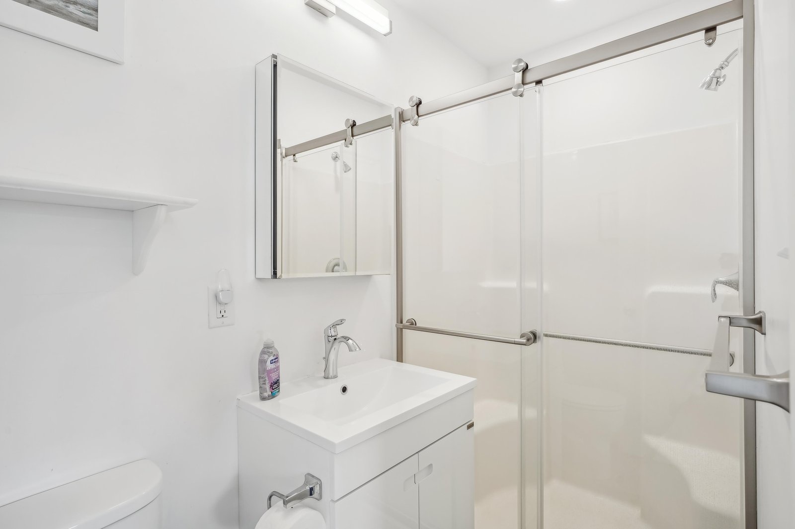 Step into your bright, modern bathroom where fresh white finishes and brushed nickel fixtures create a spa-like retreat. Enjoy your refreshing shower behind sleek glass doors.