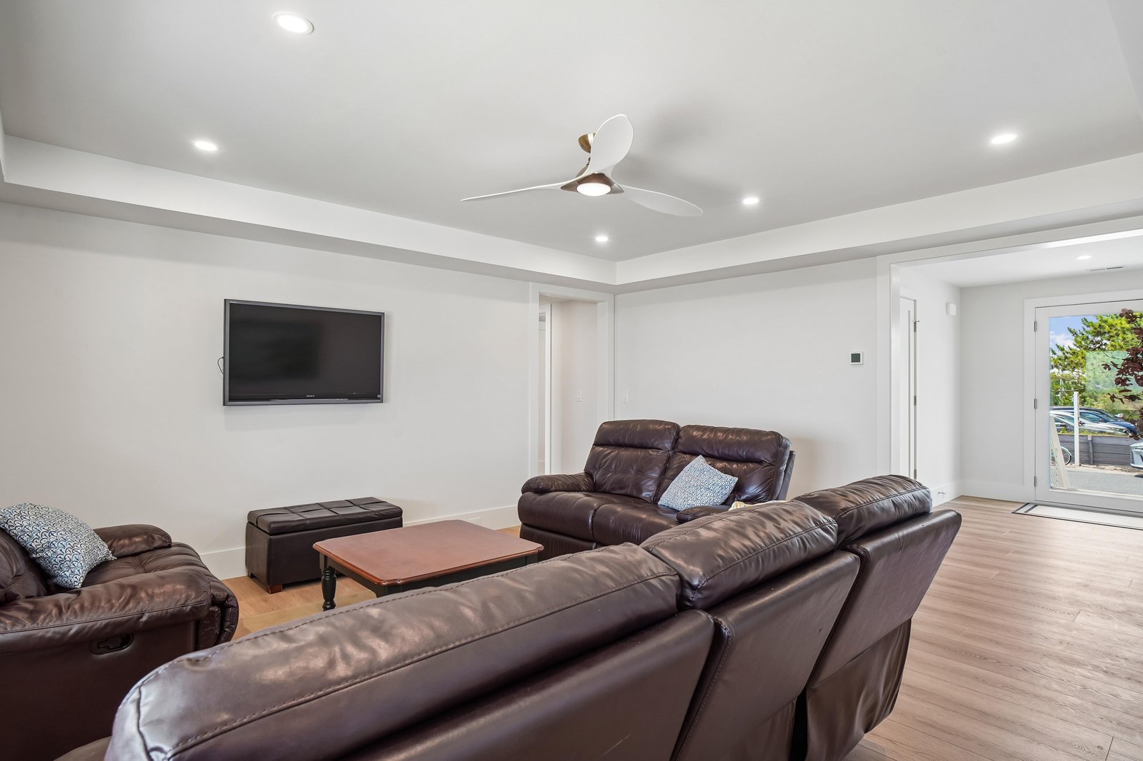 Sink into plush leather seating in your spacious living area, where modern comfort meets relaxation. Warm wood floors and a gentle ceiling fan create the perfect setting for your group to unwind together.