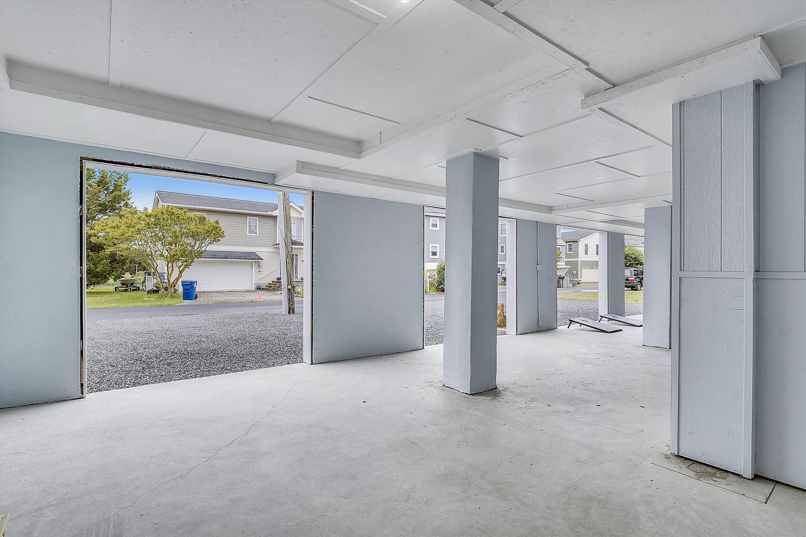 Spacious covered parking area at ground level with protected storage and direct access to surrounding neighborhood.