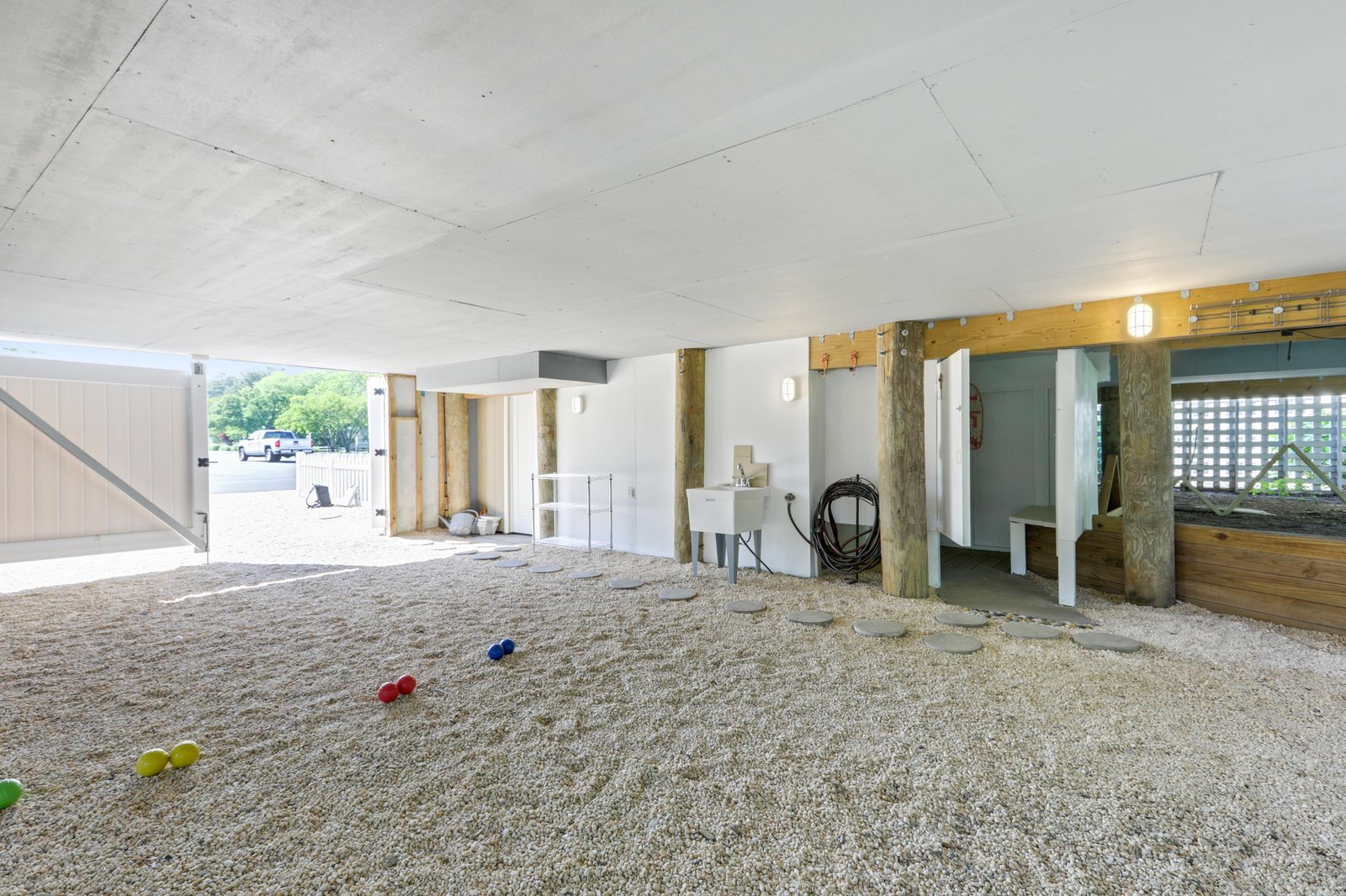 This covered ground-level area features rustic wood beams and outdoor access, offering flexible space for your gear, bikes, or beachside relaxation needs.