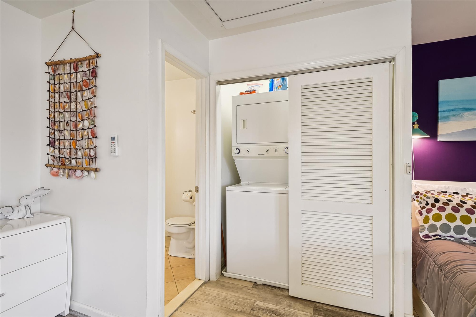 Your convenient in-unit washer and dryer combo is tucked behind a sleek louvered closet, making laundry effortless during your stay. A charming seashell collection adds coastal flair to your space.