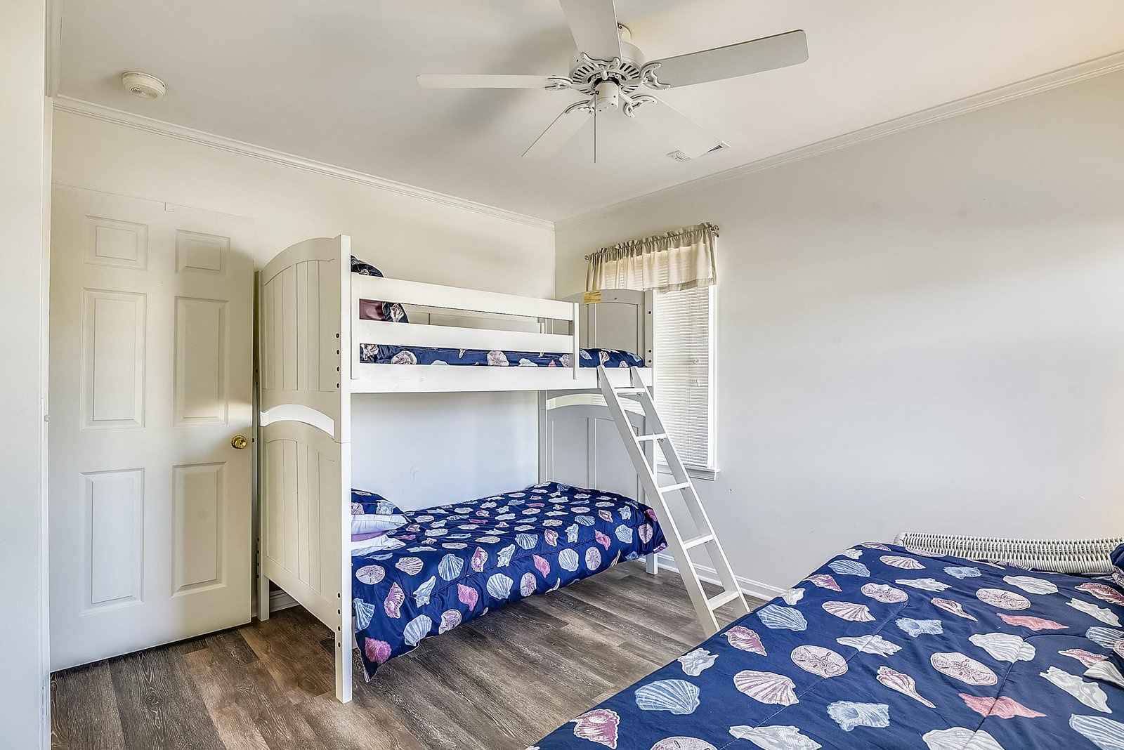 Bright, comfortable bedroom with bunk beds and coastal bedding—perfect for kids or groups sharing memories by the shore.